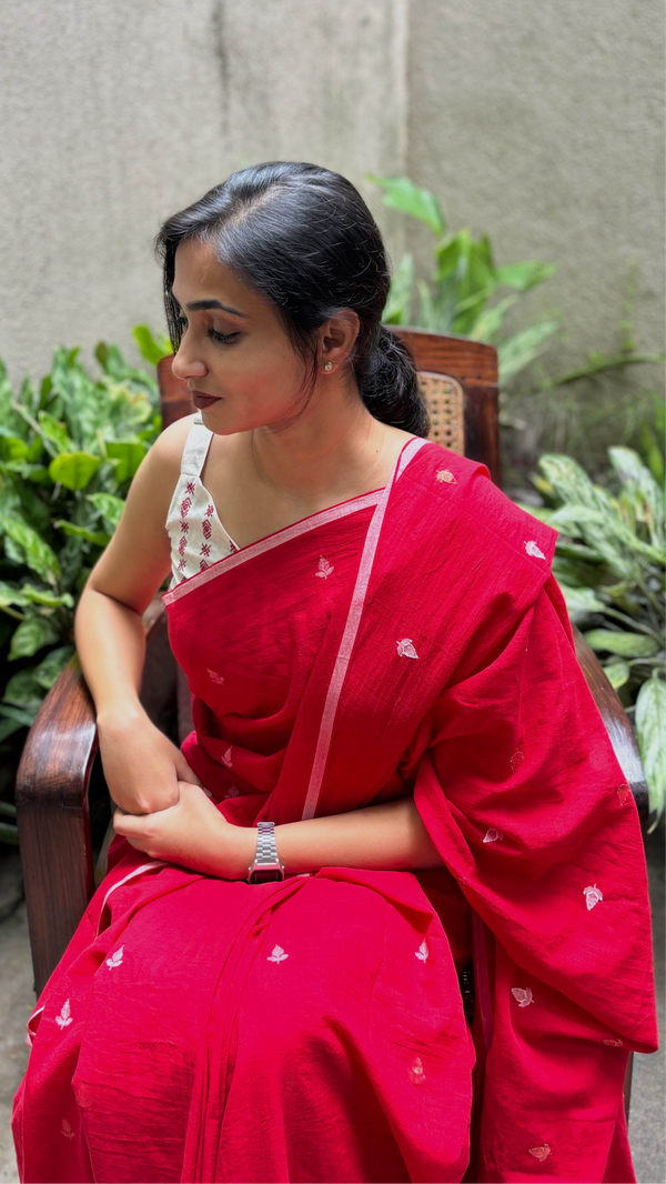 Woman wearing handcrafted Red & White Jamdani saree with intricate floral motifs.