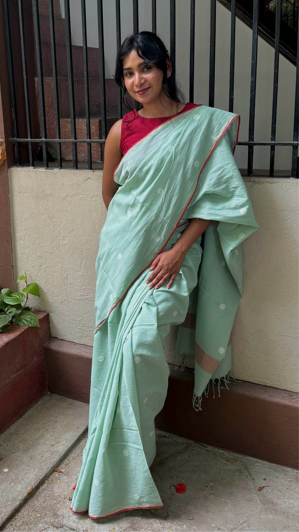 Pastel green handloom cotton Jamdani saree with red piping and white floral motifs